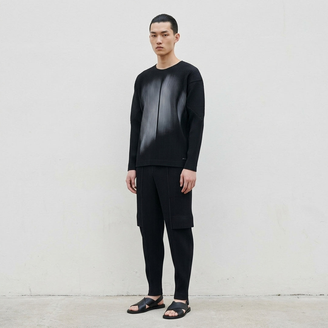Black long-sleeve pleated crew neck top by Homme Plissé Issey Miyake with a grey-blue gradient shadow print across the front - lifestyle