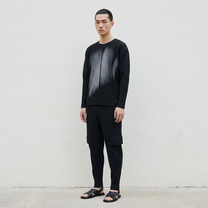 Black long-sleeve pleated crew neck top by Homme Plissé Issey Miyake with a grey-blue gradient shadow print across the front - lifestyle