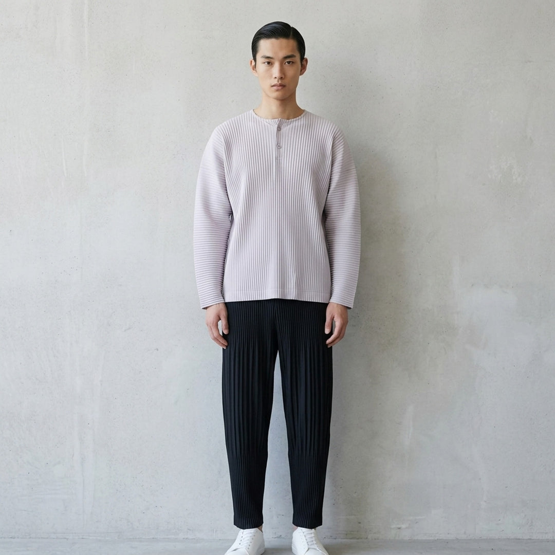 Homme Plissé Issey Miyake Monthly Colors September long-sleeve pleated top in black, featuring all-over accordion pleating and a tonal Henley button neckline - lifestyle