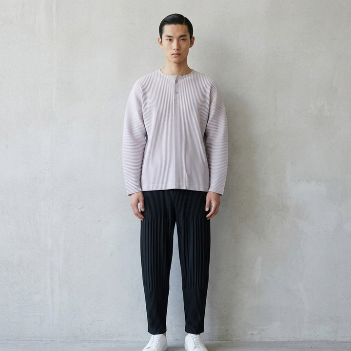 Homme Plissé Issey Miyake Monthly Colors September long-sleeve pleated top in black, featuring all-over accordion pleating and a tonal Henley button neckline - lifestyle