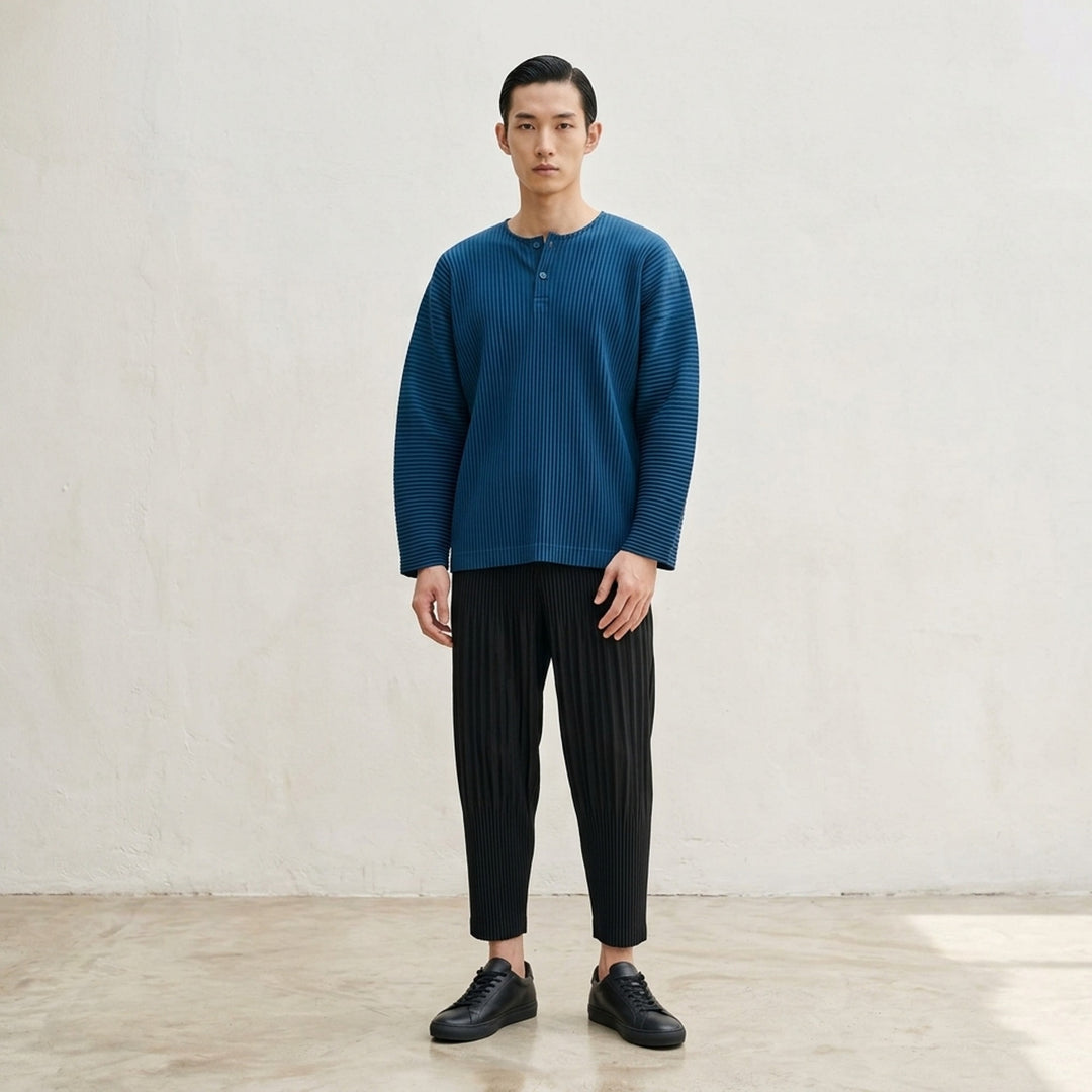 Homme Plissé Issey Miyake Monthly Colors September long-sleeve pleated top in black, featuring all-over accordion pleating and a tonal Henley button neckline - lifestyle