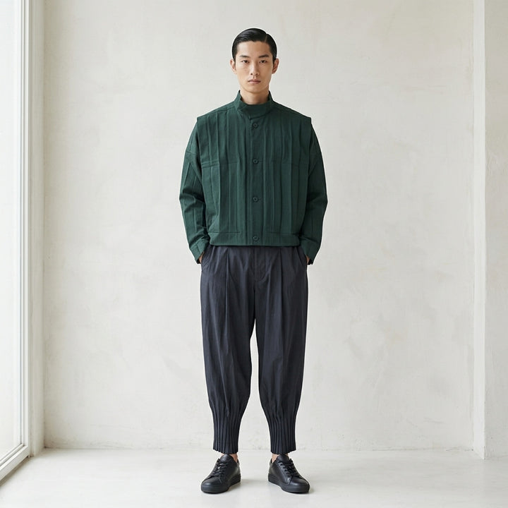 Homme Plissé Issey Miyake Edge Ensemble Pleated Blouson in deep forest green, featuring a stand collar, tonal button front, patch chest pockets, and micro-pleated fabric throughout - lifestyle