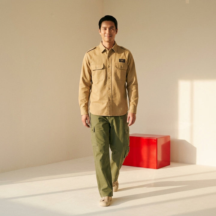 Human Made Twill Epaulette Long Sleeve Shirt in khaki cotton twill, featuring epaulette shoulders, twin flap chest pockets, button-down front placket, and a woven Human Made branding patch on the chest - lifestyle