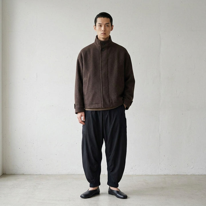 IM MEN Fuller Wool Blouson in black with stand collar, concealed button placket and slanted welt pockets, shown from the front - lifestyle