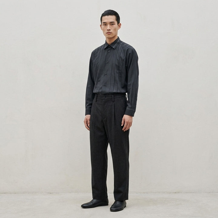 IM Men Shrink Wool woven pants in black with a front pleat, button closure and straight leg, shown from the front - lifestyle