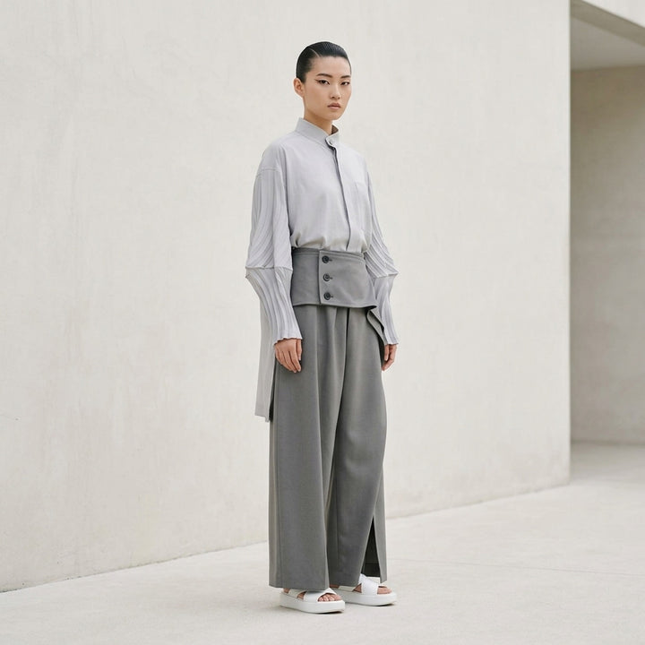 Issey Miyake CALLIGRAPH black woven wide-leg pants with high-rise wrap-fold waistband, triple-button closure, and deep pleated silhouette - lifestyle