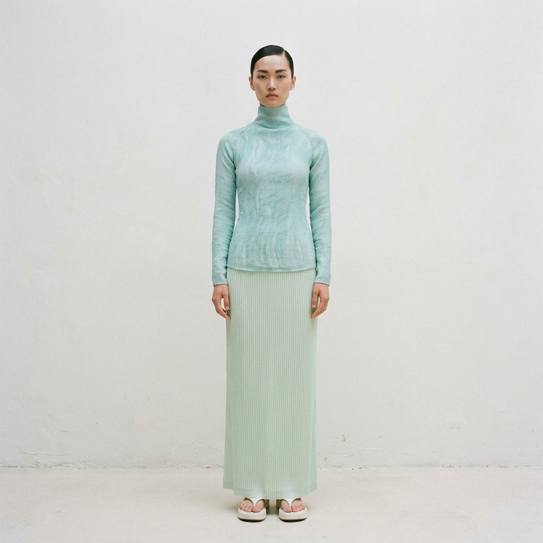 Rear view of Issey Miyake Chiffon Twist 2 woven top in grey, featuring fine horizontal pleating, a high funnel neck, and long fitted sleeves on a mannequin - lifestyle