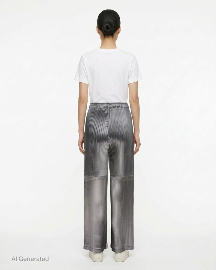 Issey Miyake glossed panels pleated pants in a metallic grey finish with an elasticated waist and wide-leg silhouette, shown from the front - back