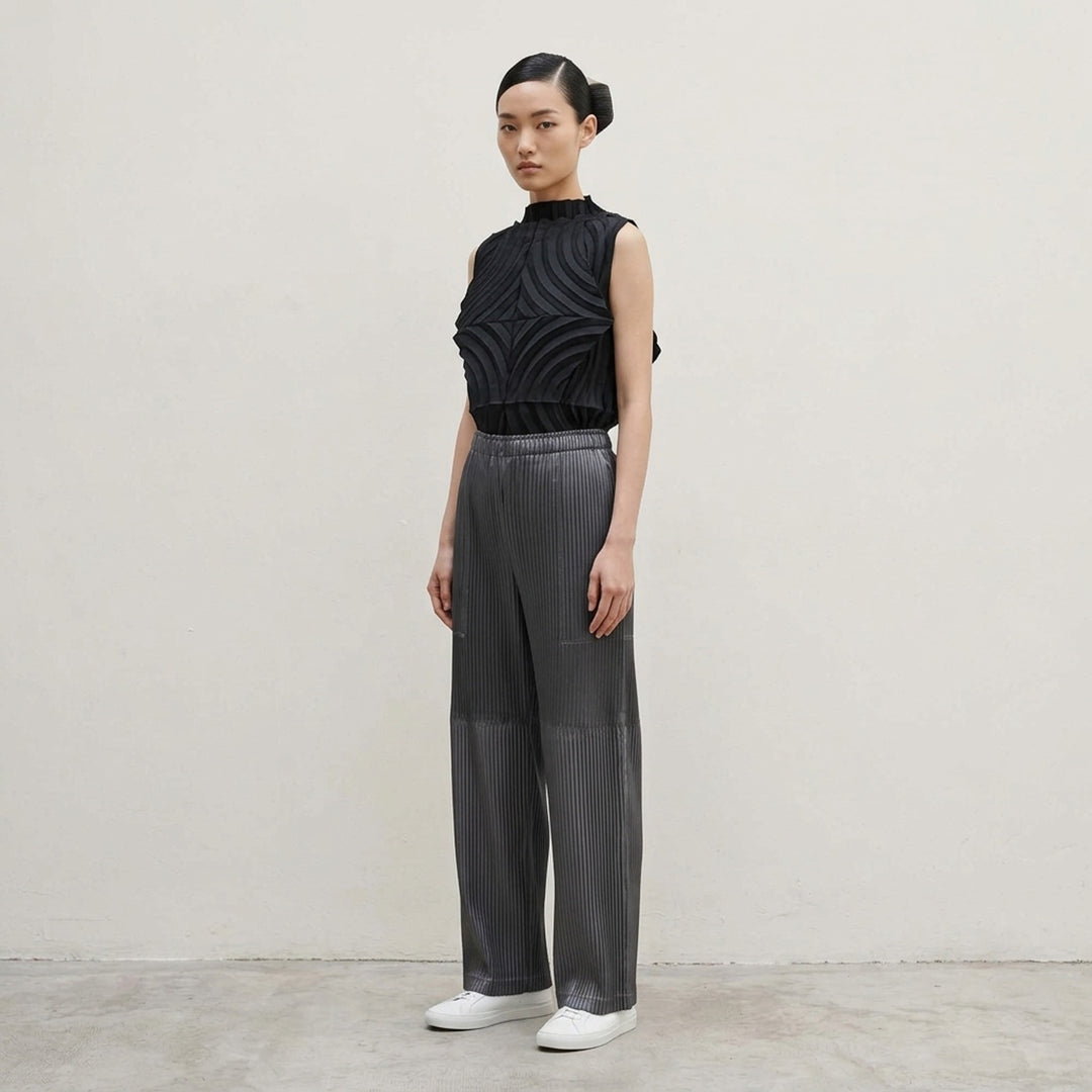 Issey Miyake glossed panels pleated pants in a metallic grey finish with an elasticated waist and wide-leg silhouette, shown from the front - lifestyle
