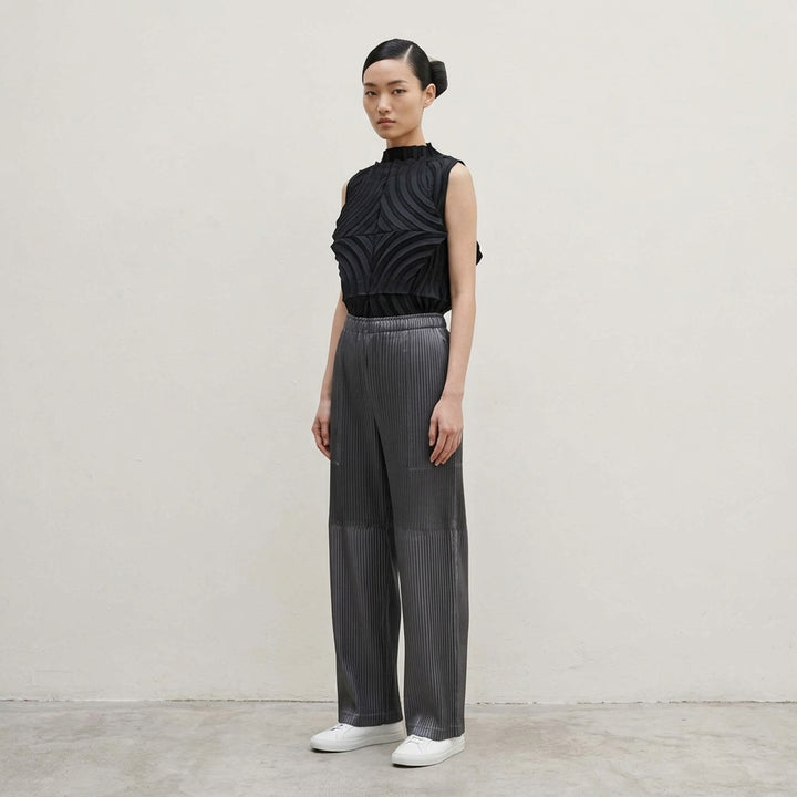 Issey Miyake glossed panels pleated pants in a metallic grey finish with an elasticated waist and wide-leg silhouette, shown from the front - lifestyle