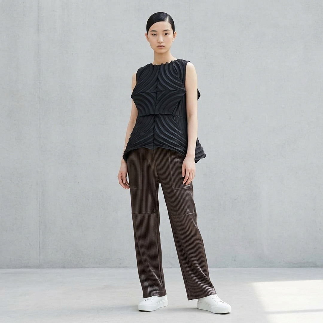 Issey Miyake glossed panels pleated pants in a metallic grey finish with an elasticated waist and wide-leg silhouette, shown from the front - lifestyle