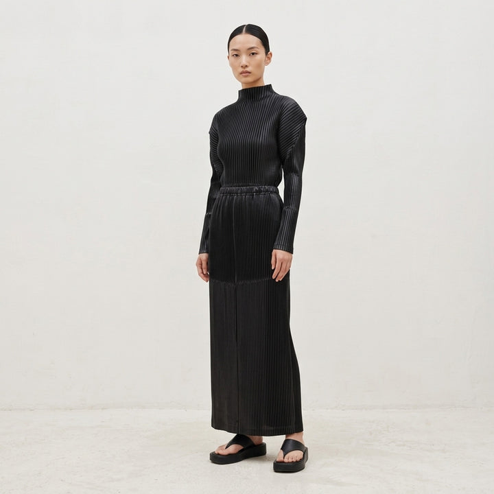 Issey Miyake Glossed Panels Pleated Skirt in black with fine vertical pleats, panelled seam detail and elasticated waistband - lifestyle