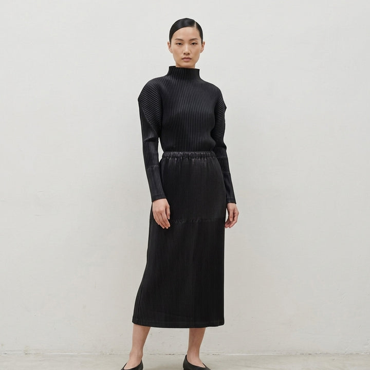 Black glossed pleated long-sleeve top by Issey Miyake with a mock neckline, sculpted shoulders and gathered waist - lifestyle