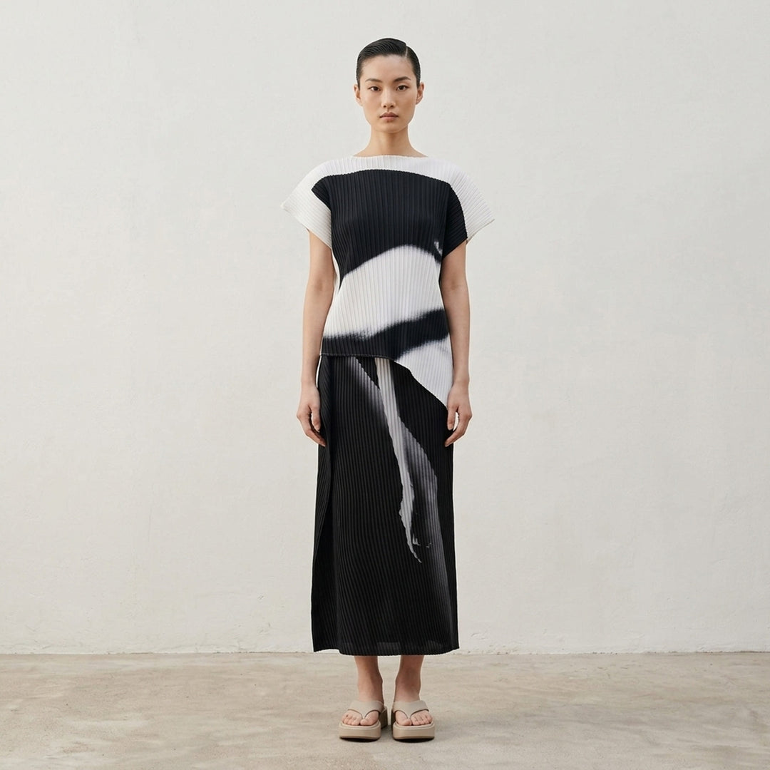Issey Miyake Hands of Lover Pleats midi skirt in dark charcoal with abstract inkwash print and asymmetric wrap-front drape, shown in profile against a white background - lifestyle