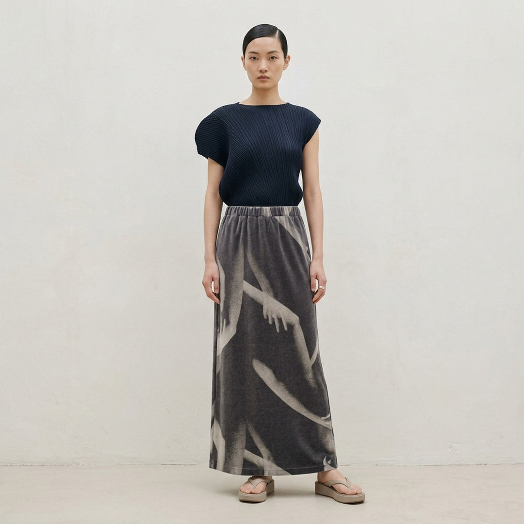 Issey Miyake Hands of Lover black velour maxi skirt with an allover monochromatic photographic print of intertwined arms and hands, shown flat against a white background - lifestyle