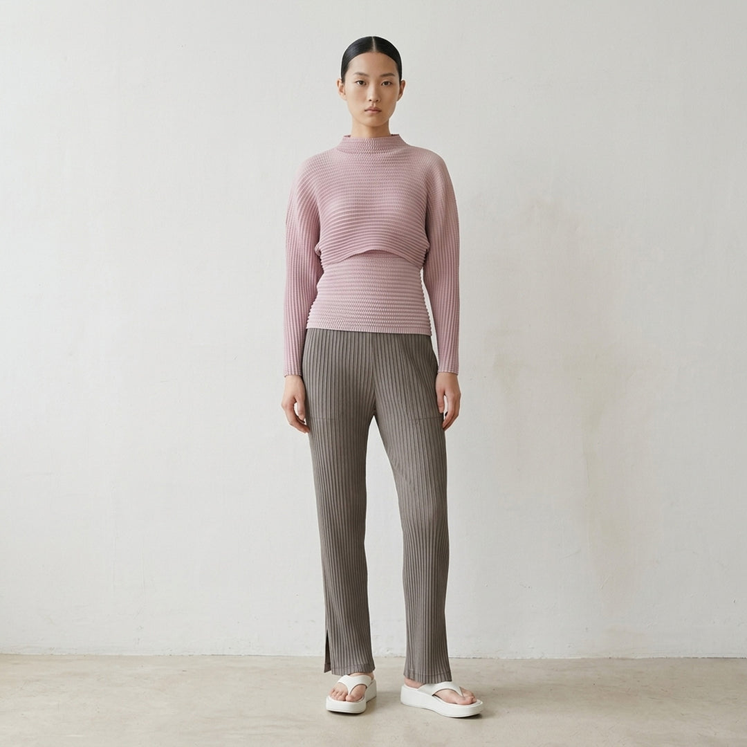 Issey Miyake Hatching Pleats pleated pants in muted taupe-grey with elasticated waist, patch pockets and straight leg, front view - lifestyle