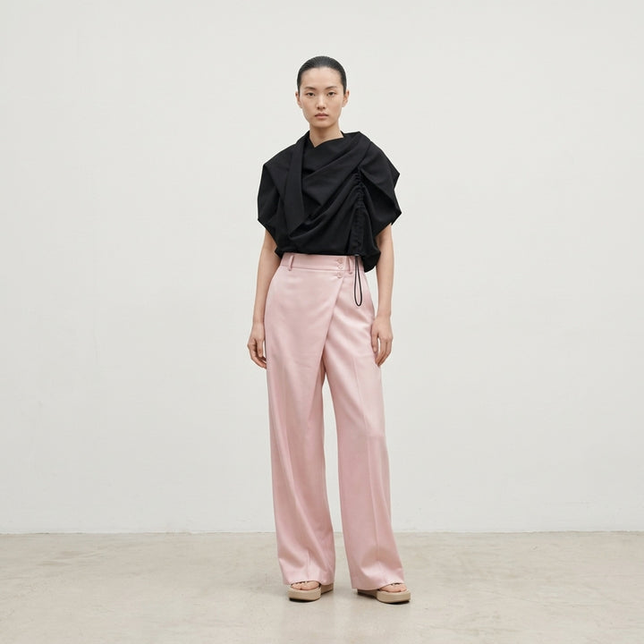 Issey Miyake Lustrous Wool Pants in black, featuring a wide-leg cropped silhouette, double front pleats, button-tab waistband, and welt rear pockets with button tab detail - lifestyle