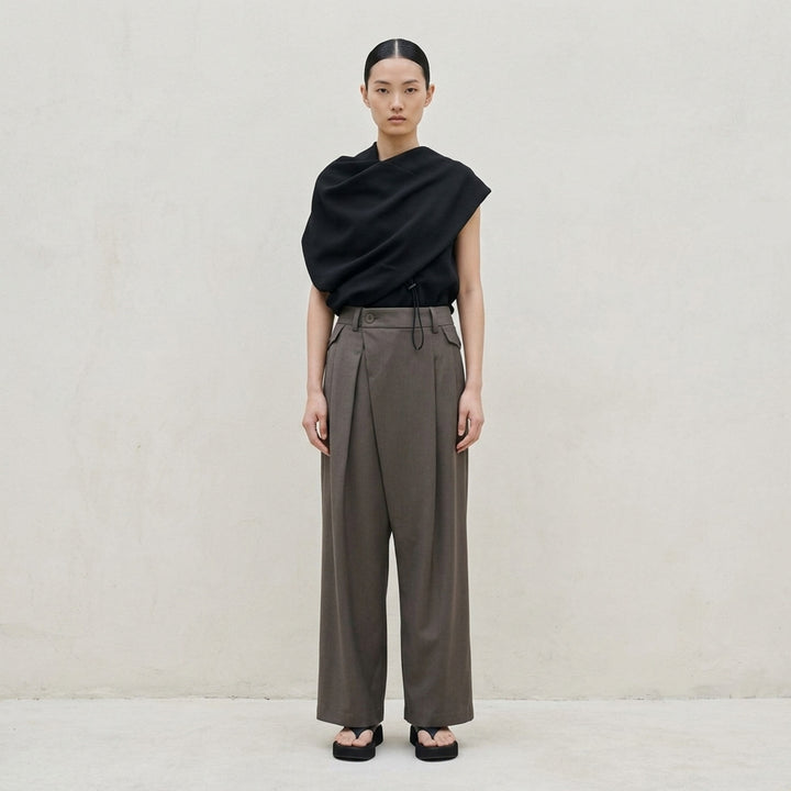 Issey Miyake Lustrous Wool Pants in black, featuring a wide-leg cropped silhouette, double front pleats, button-tab waistband, and welt rear pockets with button tab detail - lifestyle