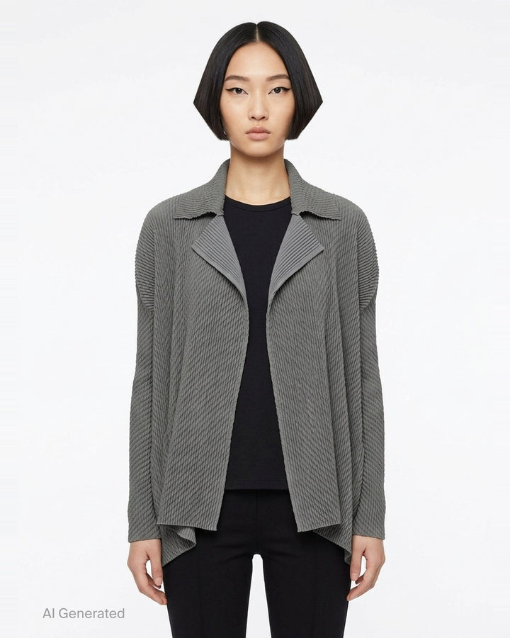 Issey Miyake Misty Pleats black pleated open-front cardigan, rear view, showing draped lapel collar, textured pleated fabric, long sleeves, and asymmetric hem - front