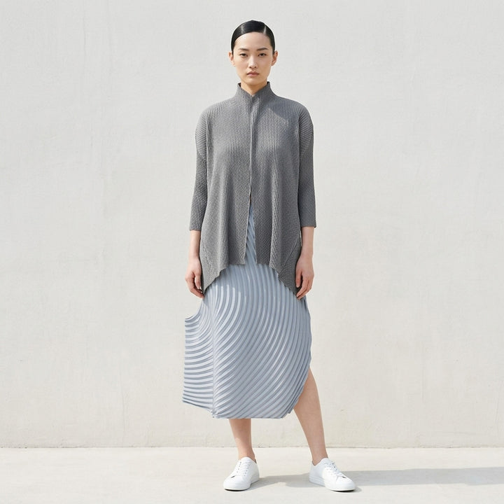 Issey Miyake Misty Pleats black pleated open-front cardigan, rear view, showing draped lapel collar, textured pleated fabric, long sleeves, and asymmetric hem - lifestyle