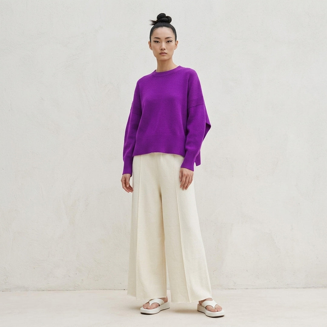 Issey Miyake O KNIT black crew neck sweater with sculptural rounded sleeves and ribbed hem and cuffs, shown from the front - lifestyle