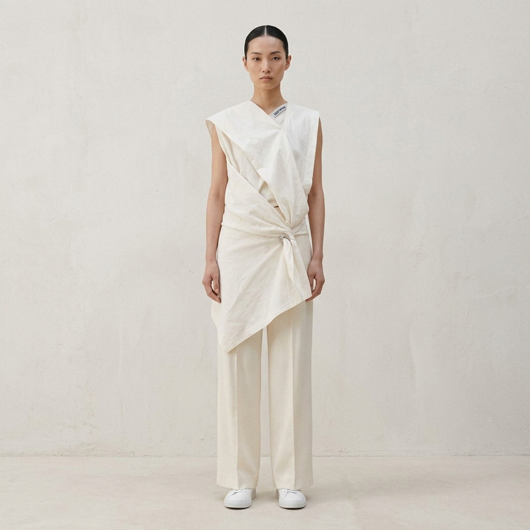 Issey Miyake Shell Woven Pants in dark navy — high-waisted wide-leg trousers with front pleats and a pressed centre crease, displayed flat on a white background - lifestyle