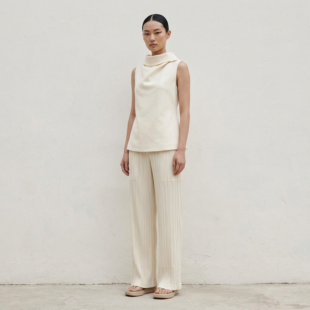 Issey Miyake Shell sleeveless top in black satin with a draped cowl neckline and gently flared silhouette, shot against a white background - lifestyle