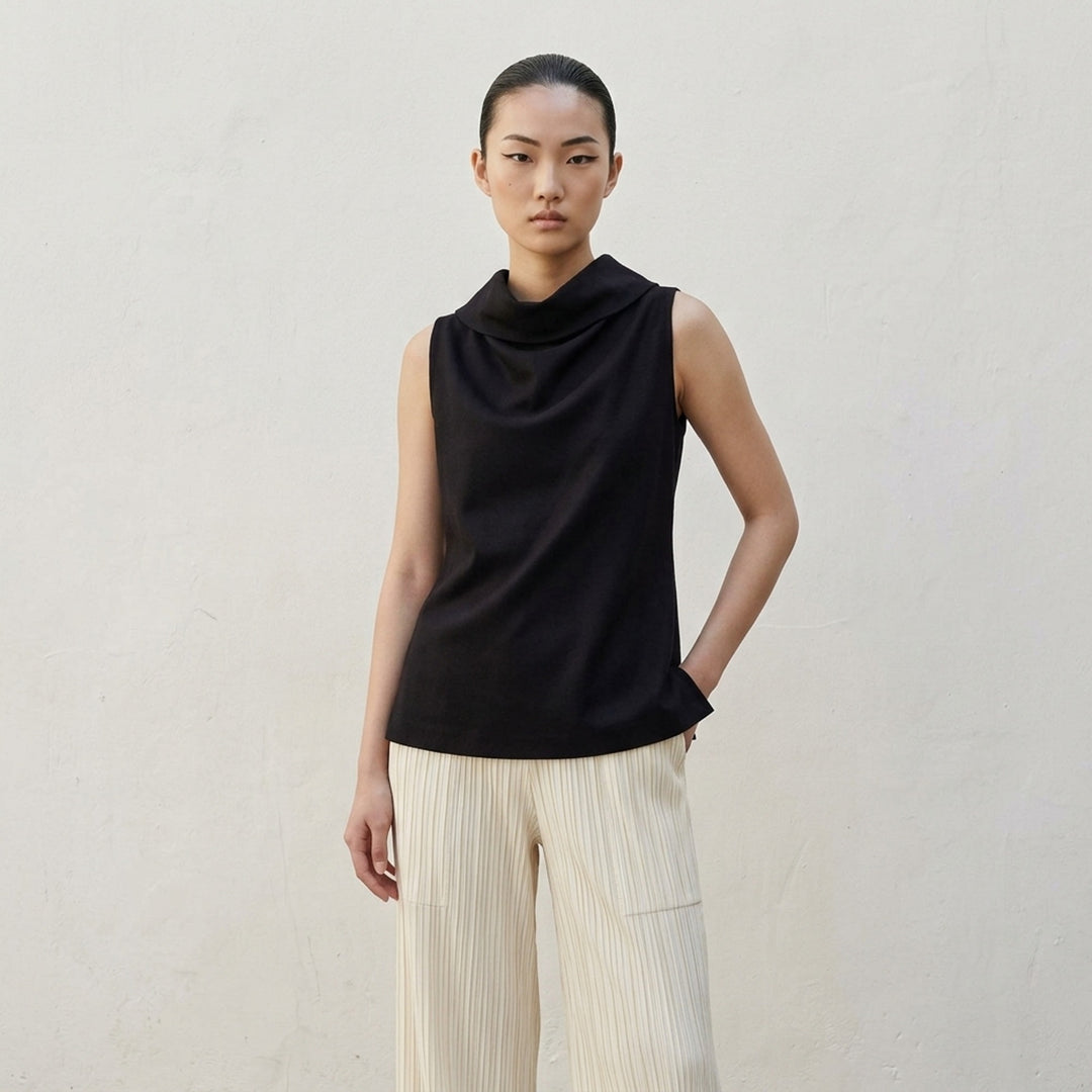 Issey Miyake Shell sleeveless top in black satin with a draped cowl neckline and gently flared silhouette, shot against a white background - lifestyle