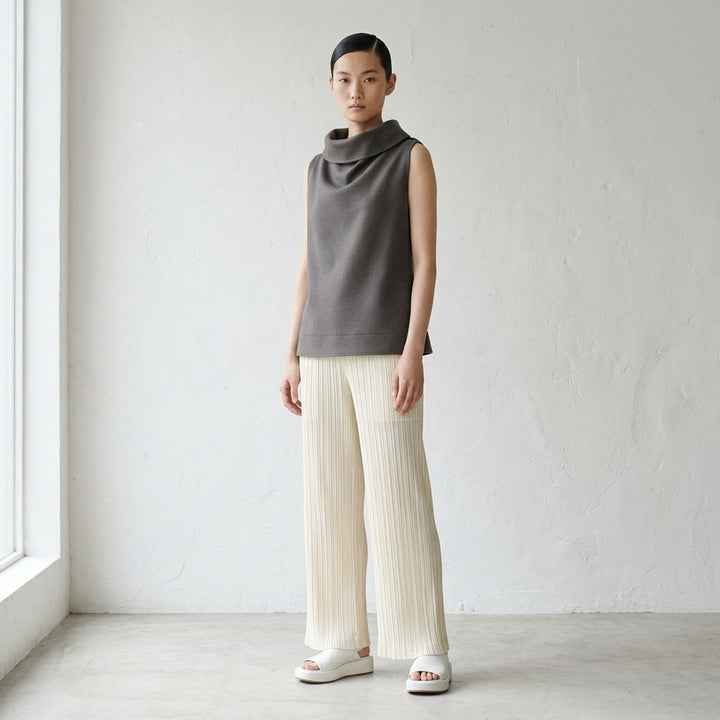 Issey Miyake Shell sleeveless top in black satin with a draped cowl neckline and gently flared silhouette, shot against a white background - lifestyle