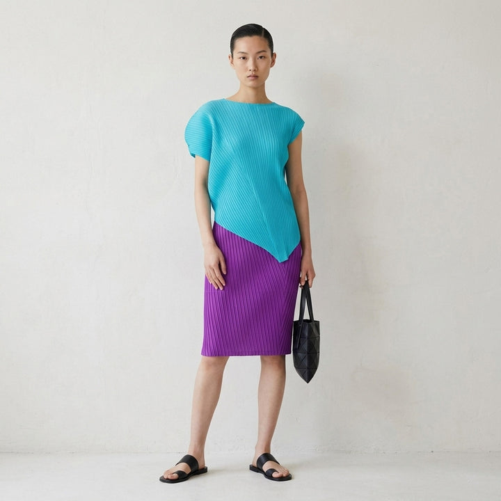 Issey Miyake Tubular Pleated Skirt in vivid purple, featuring a directional chevron pleating pattern and elasticated waistband, displayed flat against a white background - lifestyle