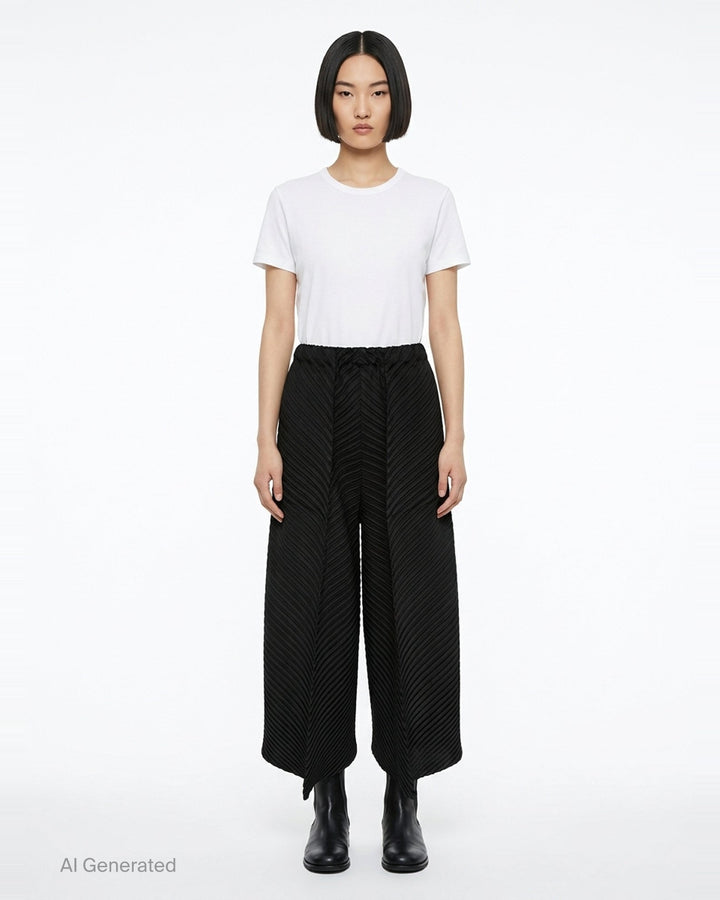 Issey Miyake Tubular Pleats wide-leg black pants with diagonal chevron pleating and elasticated waistband, displayed flat on white background - front