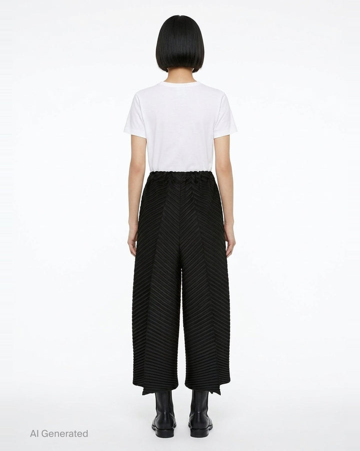 Issey Miyake Tubular Pleats wide-leg black pants with diagonal chevron pleating and elasticated waistband, displayed flat on white background - back