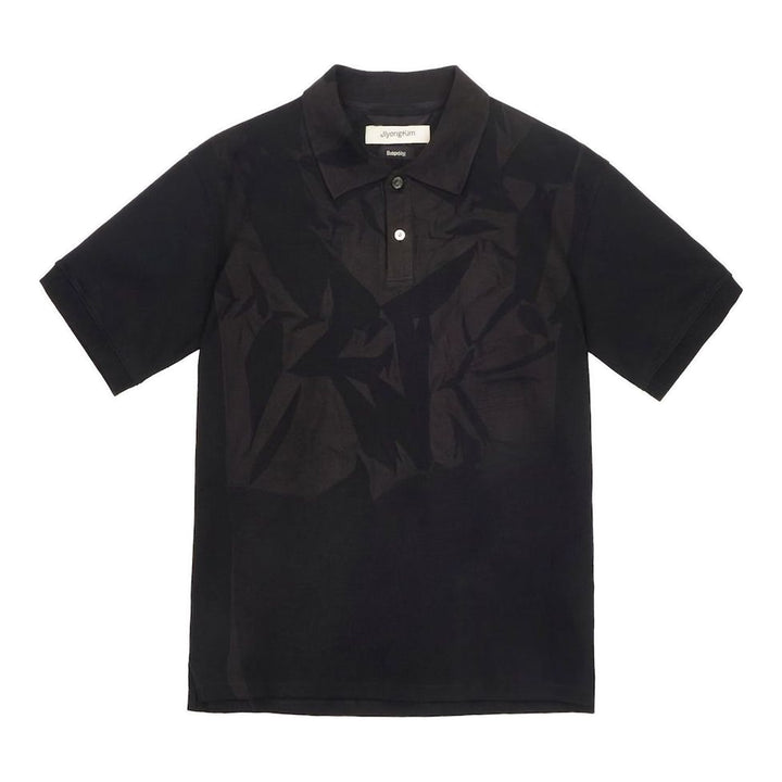 JiyongKim Sun-Bleached Pack Polo in black, displayed flat, featuring a tonal crumpled-fabric graphic panel across the front chest and a two-button placket - packshot