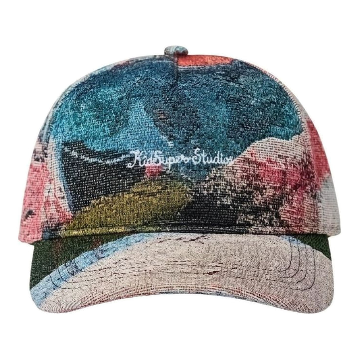 KidSuper Studios jacquard art cap in a multicolour painterly woven pattern with white embroidered script logo, front view - packshot