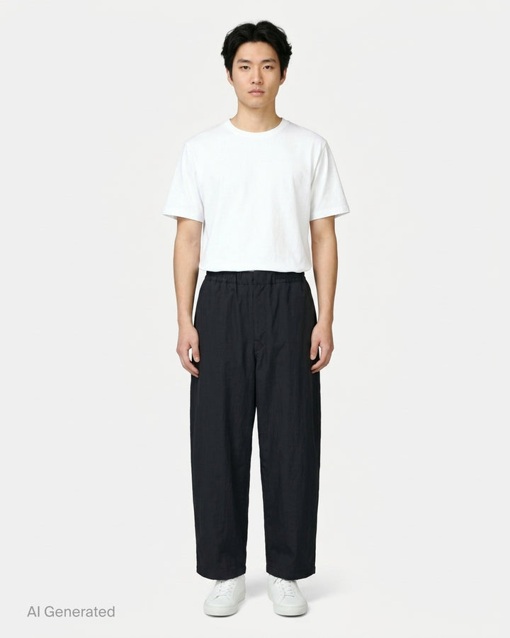 Lemaire black wool gabardine jogger pants with an elasticated waist and relaxed wide-leg silhouette, shown from the front - front