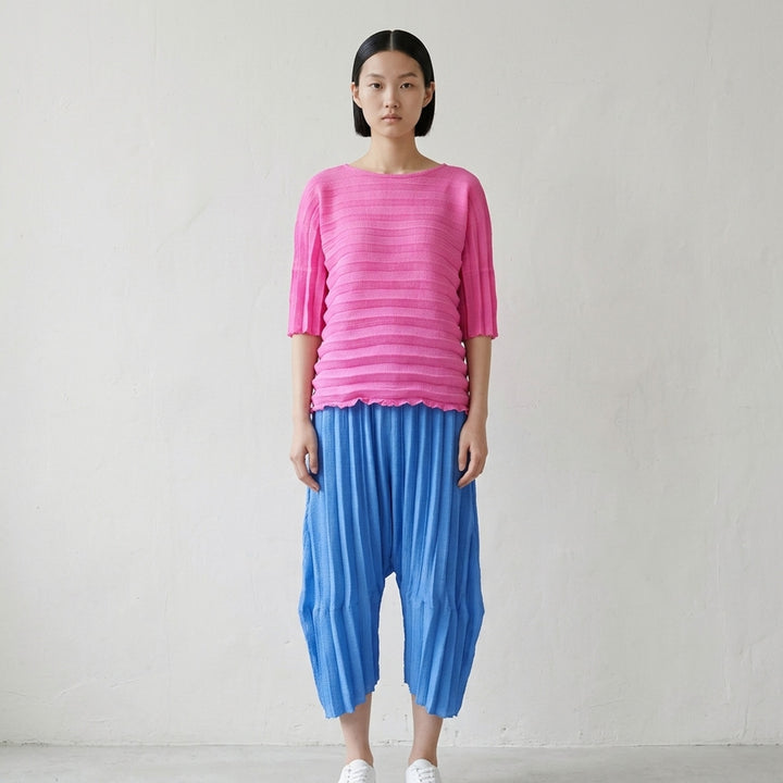 me Issey Miyake Accordion See-Through Crepe top in dusty blue, featuring horizontal accordion pleating, oversized boxy silhouette, elbow-length sleeves, and a gathered ruched hem, photographed flat on a white background - lifestyle