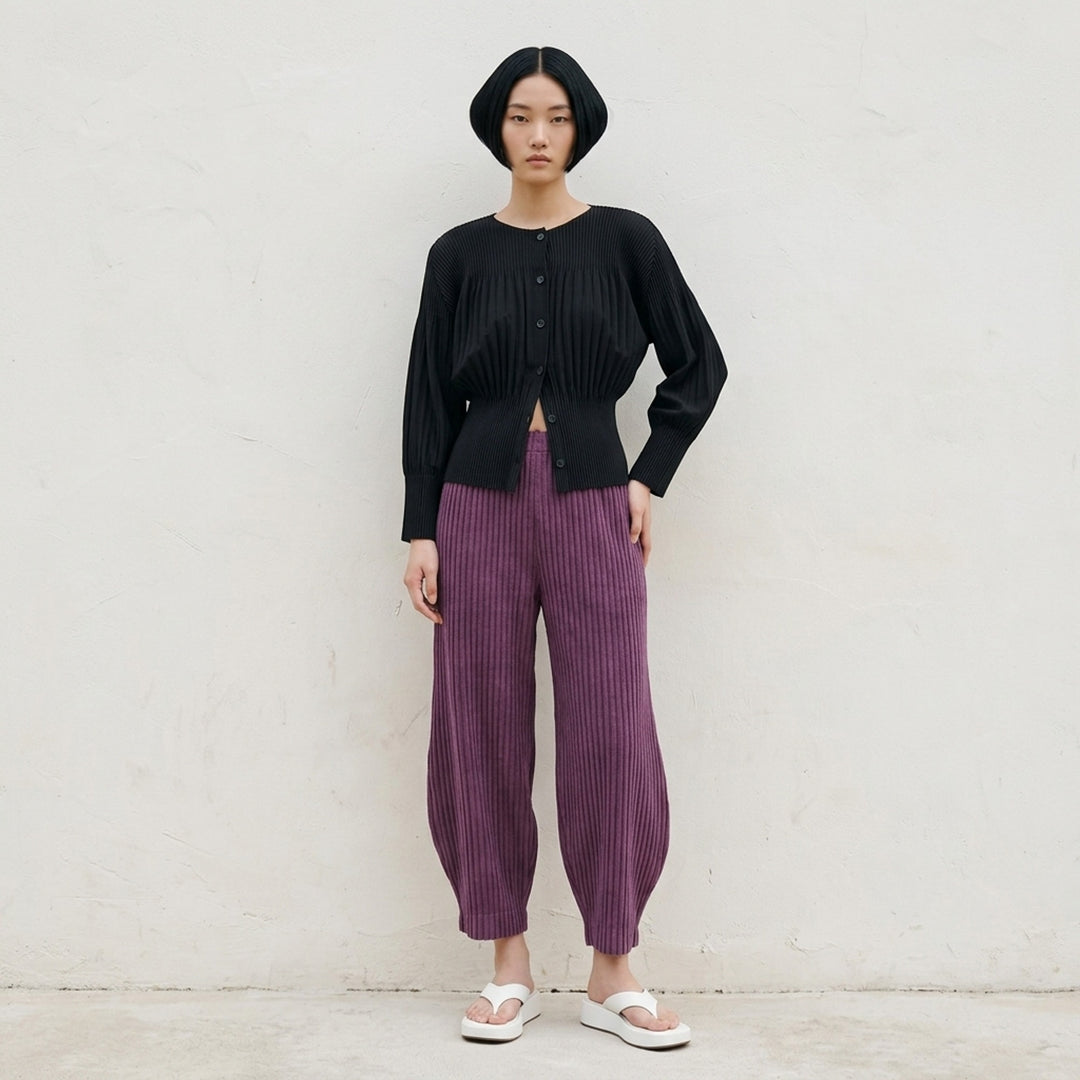 me Issey Miyake Corduroy Pleats black ribbed pleated pants with elasticated waist and curved, tapered leg, front view - lifestyle