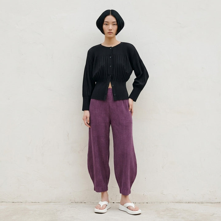 me Issey Miyake Corduroy Pleats black ribbed pleated pants with elasticated waist and curved, tapered leg, front view - lifestyle