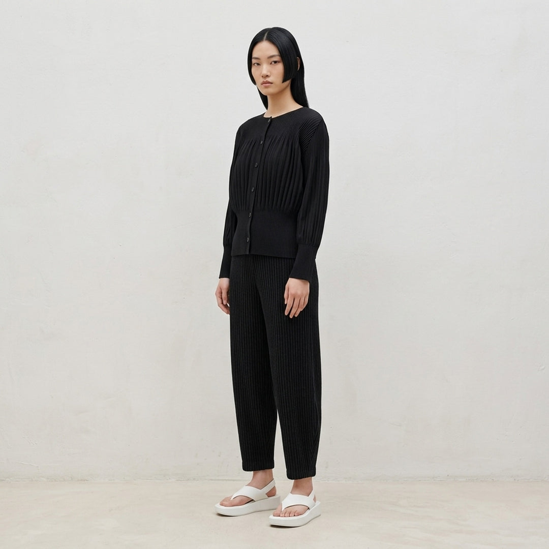 me Issey Miyake Corduroy Pleats black ribbed pleated pants with elasticated waist and curved, tapered leg, front view - lifestyle
