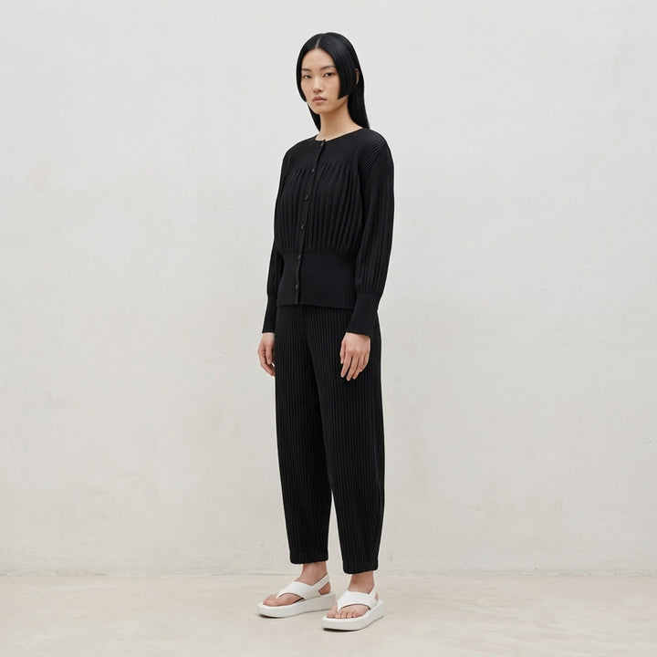 me Issey Miyake Corduroy Pleats black ribbed pleated pants with elasticated waist and curved, tapered leg, front view - lifestyle