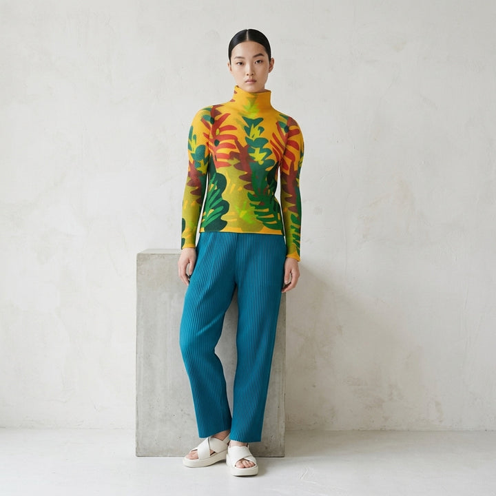 me Issey Miyake Jungle long sleeve turtleneck pleated top with a vibrant abstract botanical print in amber, green, teal, and red tones - lifestyle