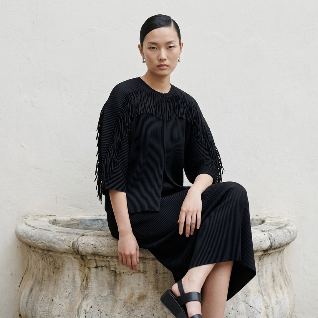 me Issey Miyake Leaf Pleats Cardigan in black, back view, showing tonal button closure, all-over relief pleating, wide sleeves with tie cuffs, and relaxed cropped silhouette - lifestyle