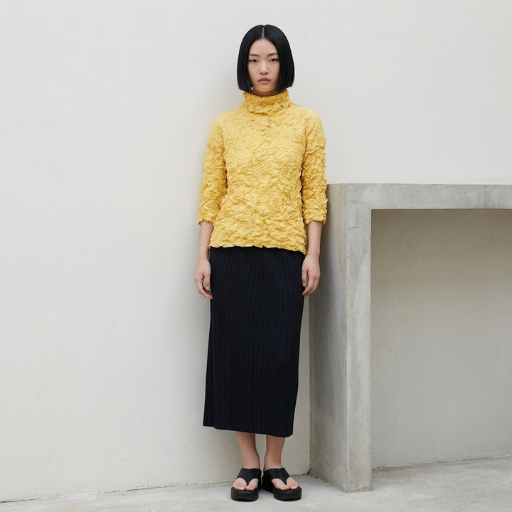me Issey Miyake Meringue Top in black with allover crinkled texture, funnel neckline and short sleeves - lifestyle