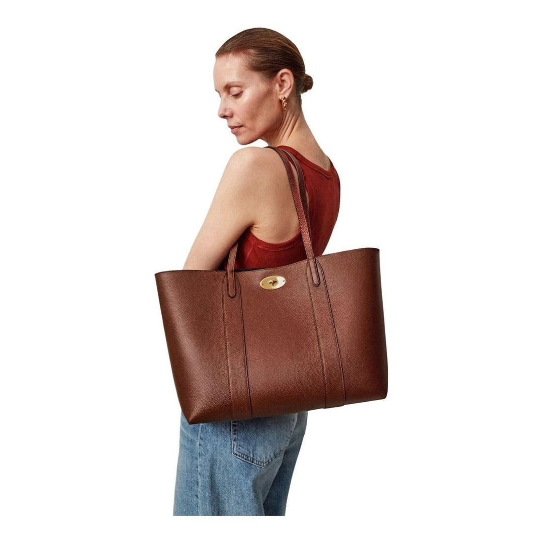 Mulberry Bayswater Two Tone Tote in tan pebbled leather with gold postman's lock closure and navy interior lining, shot against a neutral background - packshot