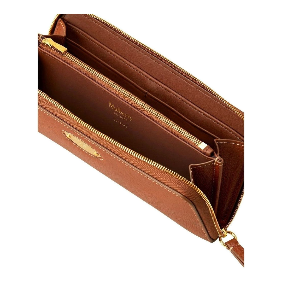 Mulberry Plaque 8 CC Zip Purse in tan grained leather with gold-tone oval plaque hardware and contrast topstitching, laid flat on a neutral background - packshot