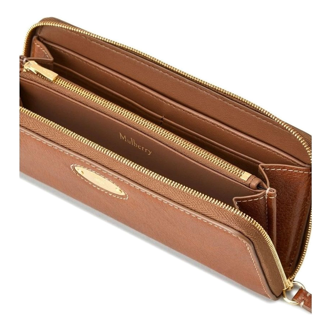 Mulberry Plaque 8 CC Zip Purse in tan grained leather with gold-tone oval plaque hardware and contrast topstitching, laid flat on a neutral background - packshot