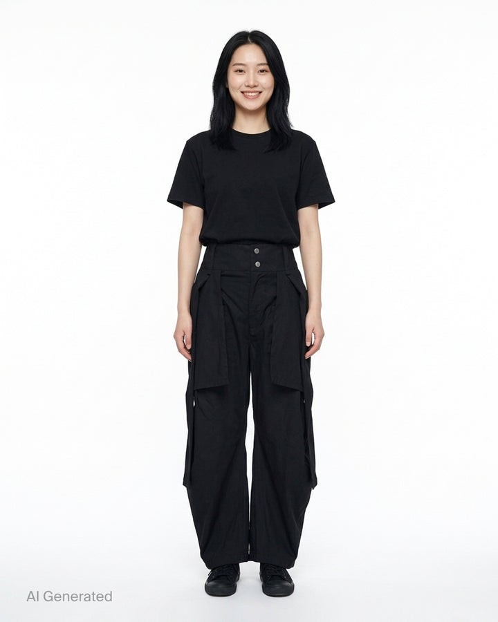 Nache Tied Shirt Pants in black, shown from the front with high waist, double snap closure and draped sleeve ties at the hips - front