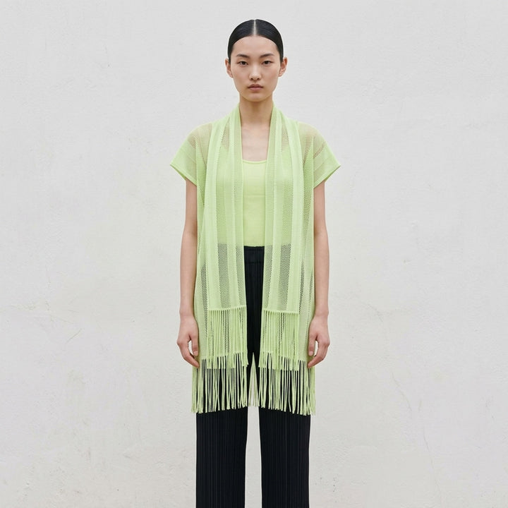 Pleats Please Issey Miyake A-POC LACE black fishnet mesh open-front tunic with draped scarf collar, cap sleeves, and dense knotted fringe hem, displayed flat on white background - lifestyle