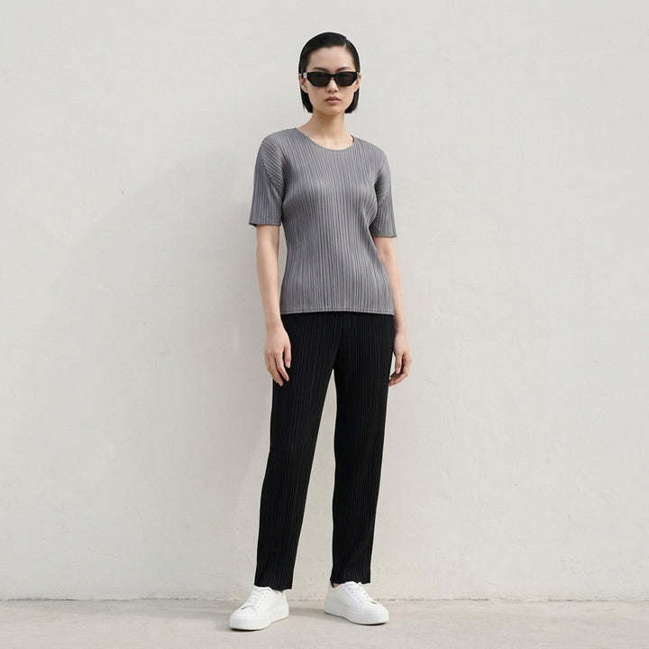 Pleats Please Issey Miyake black short sleeve pleated top with round neckline, front view - lifestyle