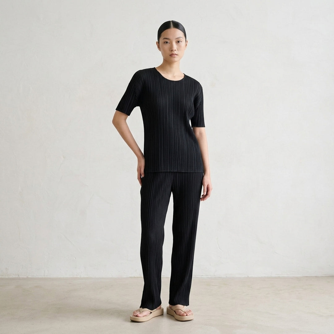 Pleats Please Issey Miyake black short sleeve pleated top with round neckline, front view - lifestyle